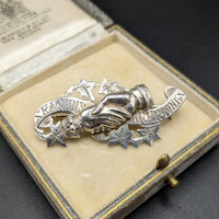 The Vintage Vault antique 1908 Edwardian sterling silver handshake brooch with etched leaf and scroll details.