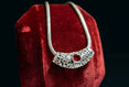 The Vintage Vault vintage sterling silver necklace featuring a polished Bali style sliding pendant with a red garnet.